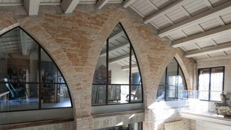 Finestre ad arco in ferro e mattoni a vista