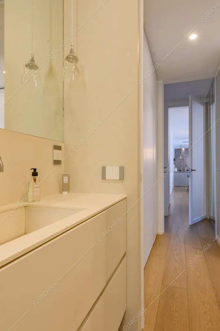 Lungo bagno con pareti bianche, pavimento in parquet e vista sulla cucina