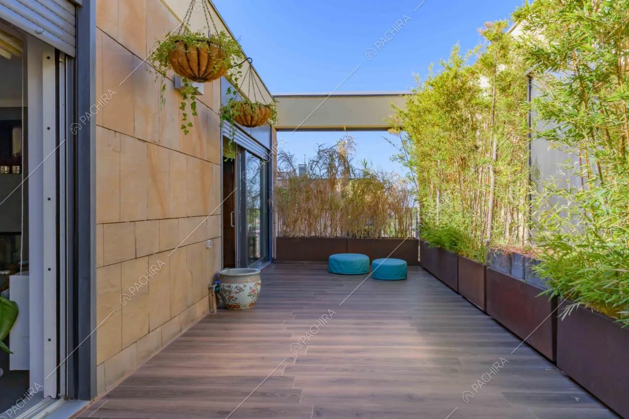 Terrazza con pavimento in parquet da esterni, pouf azzurri e bambù