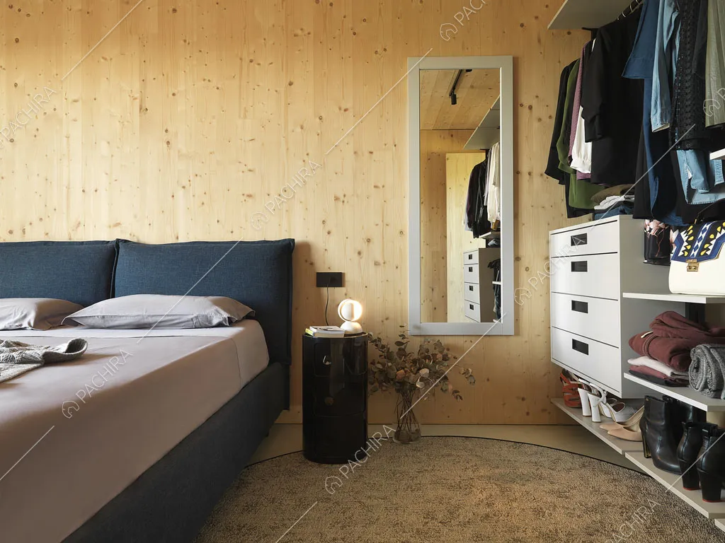 Parete in legno nella luminosa camera da letto matrimoniale con porta-finestra