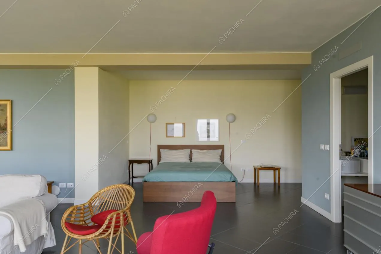 Ampia camera da letto matrimoniale dalle pareti gialle e azzurre
