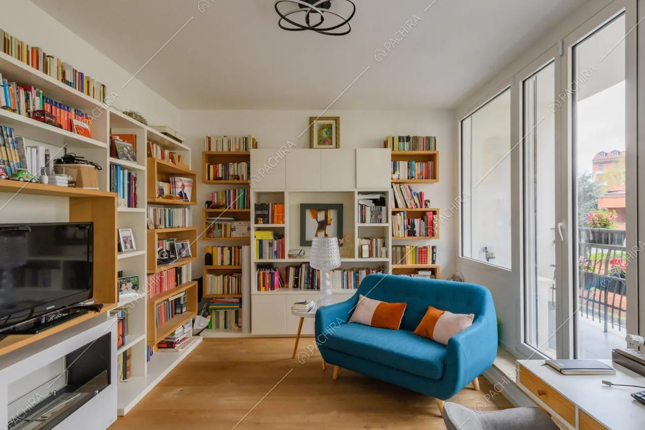Salotto con libreria, pavimento in parquet e porte-finestre per accedere al balcone