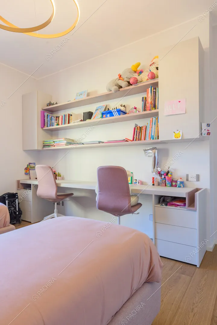 Camera da letto dei bambini con scrivania bianca e pavimento in parquet