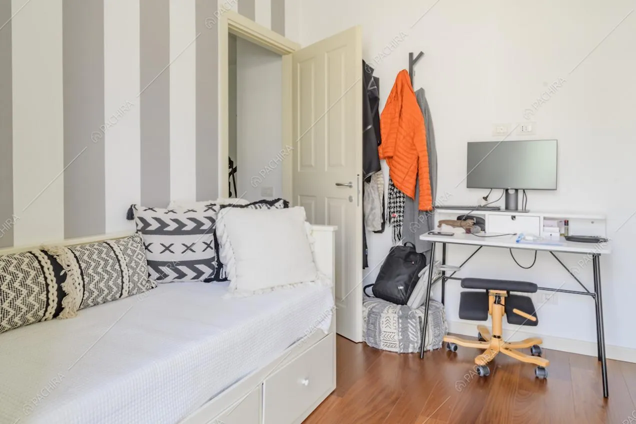 Camera da letto con pareti a strisce verticali grigie e bianche