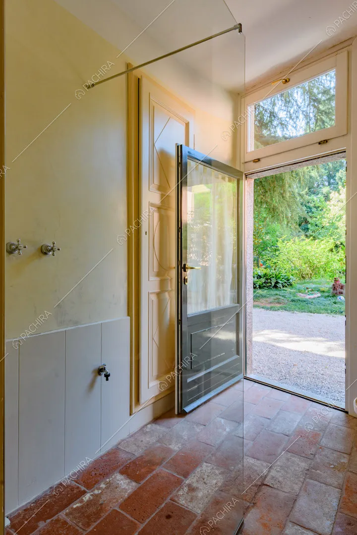 Bagno della location con pareti gialle e bianche, porta a vetri e pavimento in cotto