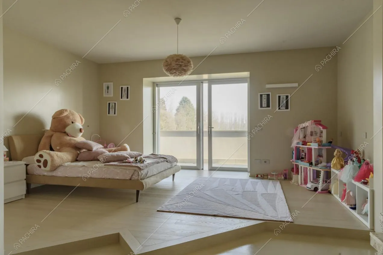 Camera da bambini con letto su un rialzo, pareti beige e porta-finestra con accesso alla terrazza