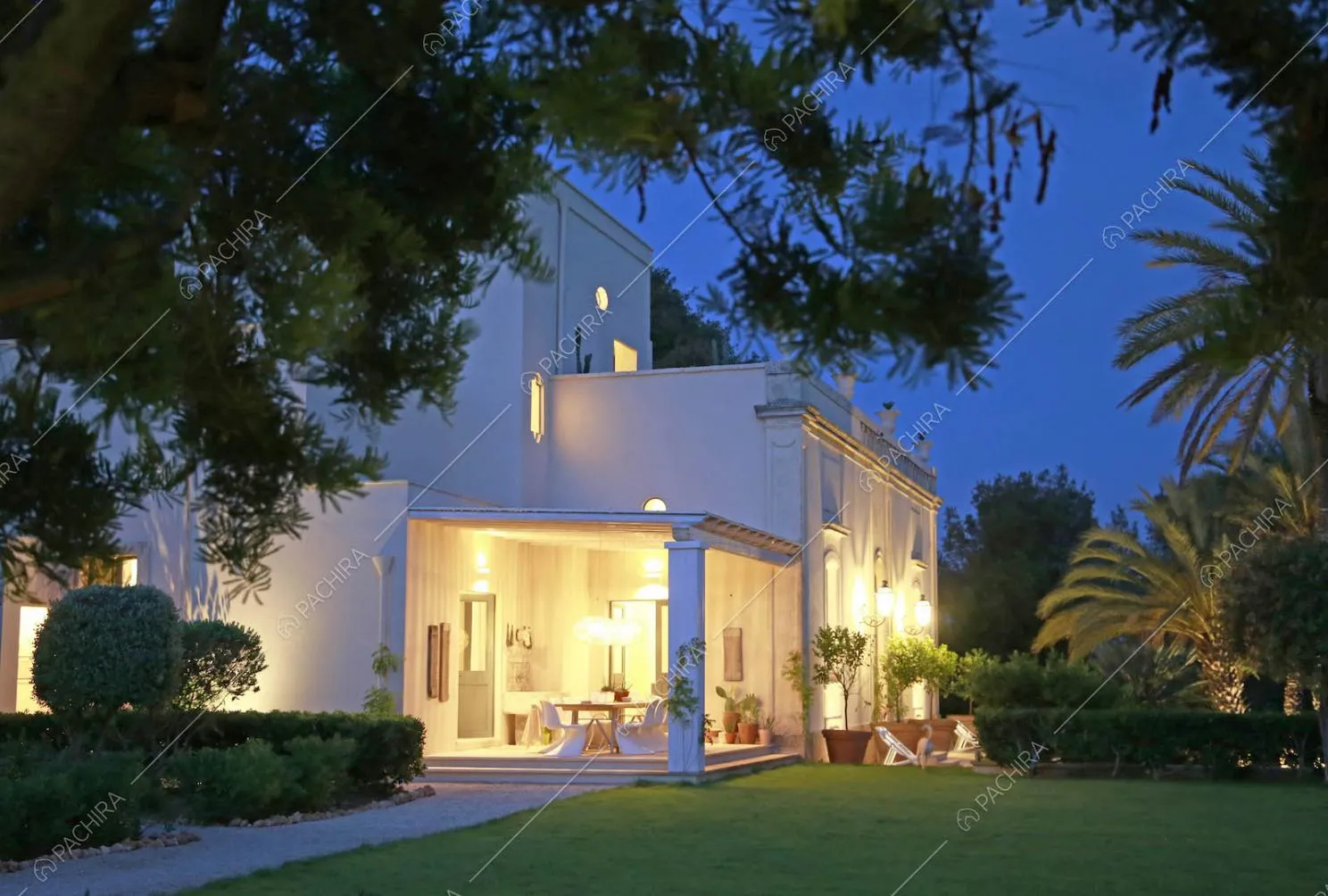 Vista sulla veranda e sugli esterni bianchi della villa dal giardino