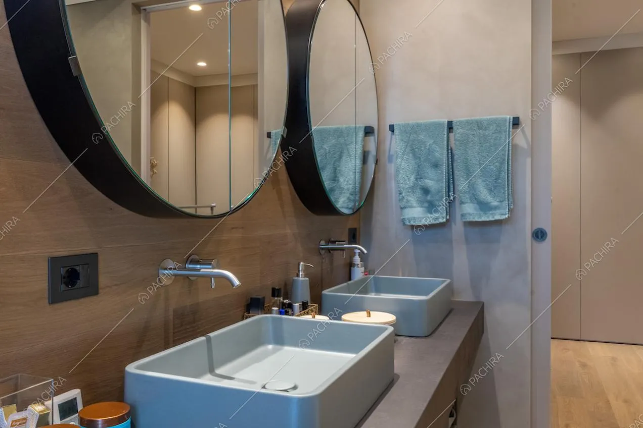 Bagno con doppio lavandino, specchi di design e vista sul corridoio