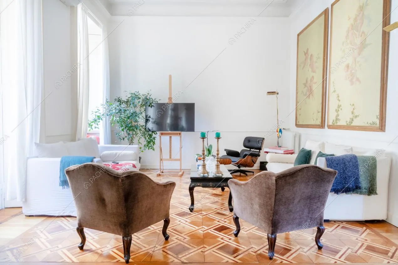 Luminoso salotto dalle pareti bianche con boiserie e dal pavimento in parquet