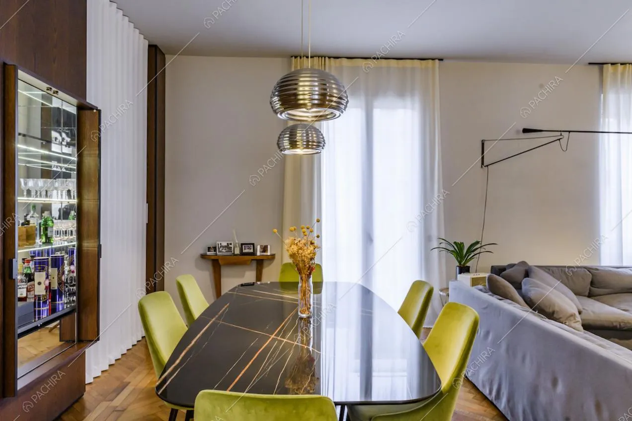 Sala da pranzo con pareti color panna e tende bianche
