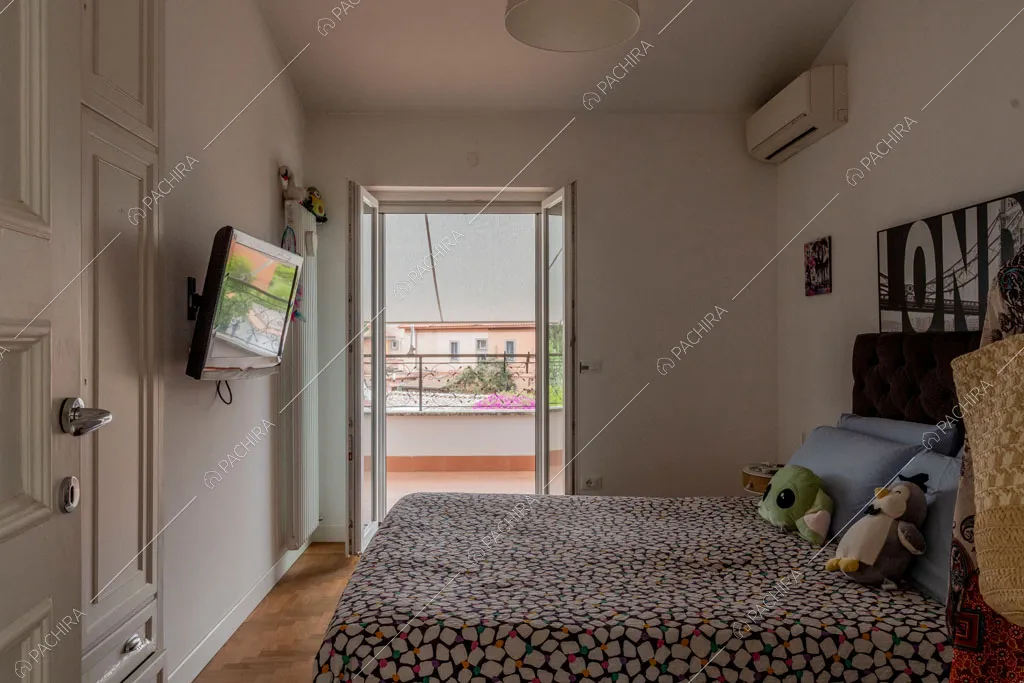 Camera da letto con porta finestra della villa Pino Mugo, location in stile moderno a Roma