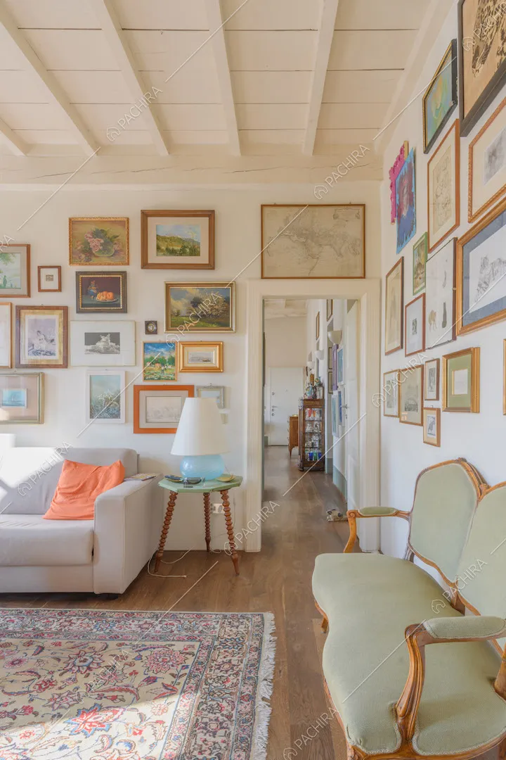Divano antico verde, pavimento in parquet, pareti bianche e soffitto a cassettoni