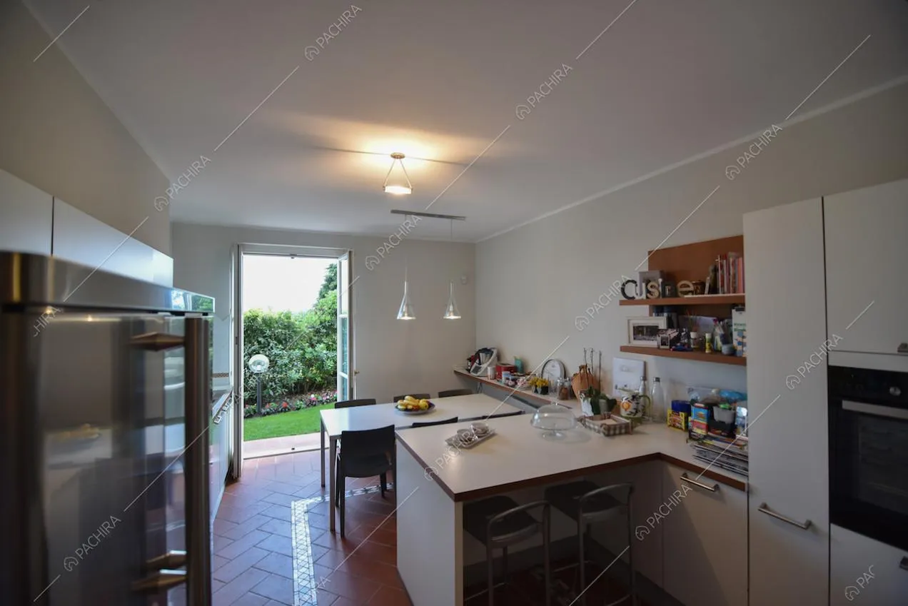 Cucina con elettrodomestici e accesso al giardino