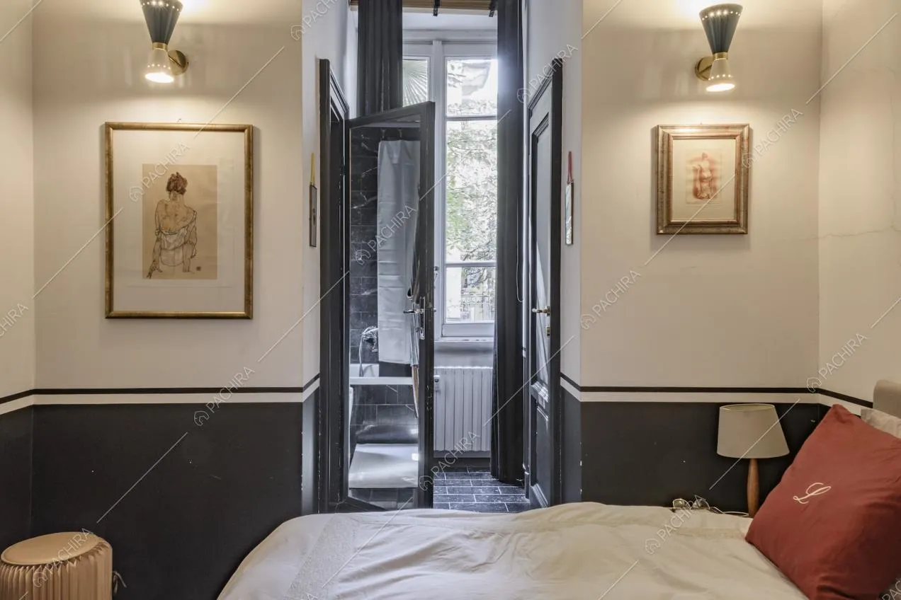 Camera matrimoniale con pouf e quadri alle pareti