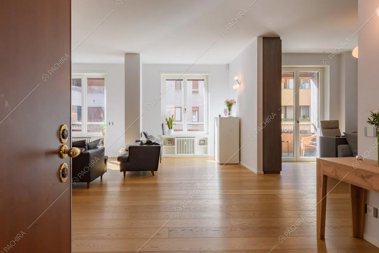 Dalla porta d'ingresso vista sulla zona living con pavimento in parquet e porta-finestra