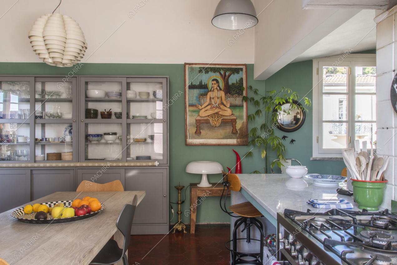 Grande credenza color grigio chiaro con ante in vetro e fornelli a gas