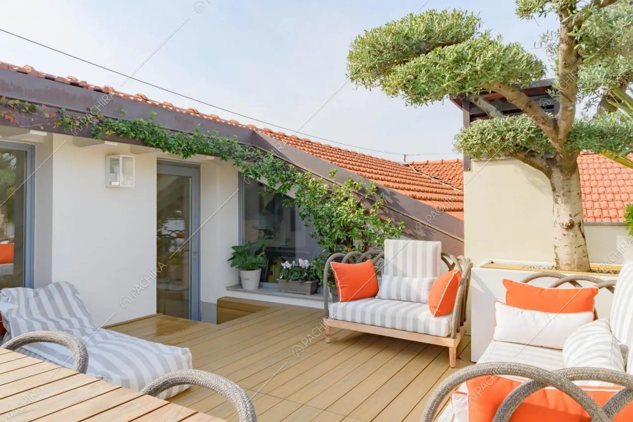 Pavimento in parquet sulla terrazza con divani e pouf bianchi e grigi