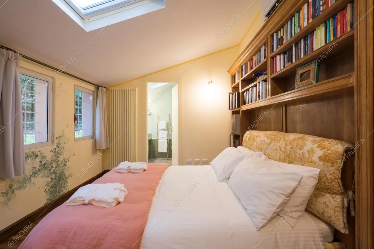Camera da letto con lucernario e libreria a parete