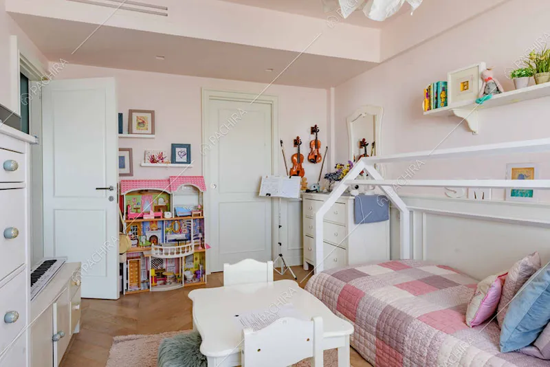 Pareti rosa nella camera da letto da bambini con pavimento in parquet