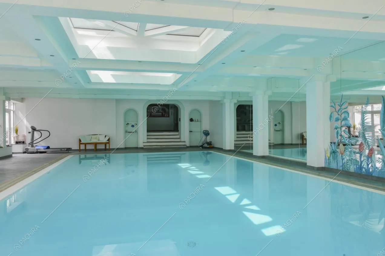Piscina al chiuso luminosa grazie ai lucernari sul soffitto e alle ampie vetrate