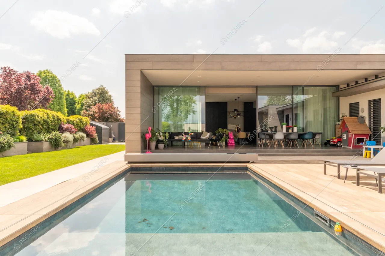 Dalla piscina vista sulla zona living attraverso le ampie porte-finestre scorrevoli