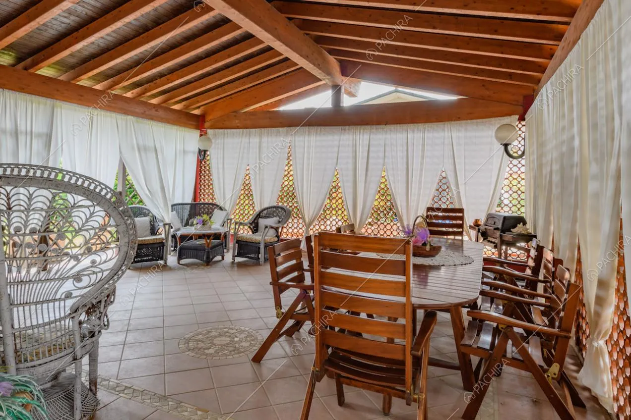Luminosa veranda con travi in legno a vista e tavolo da pranzo