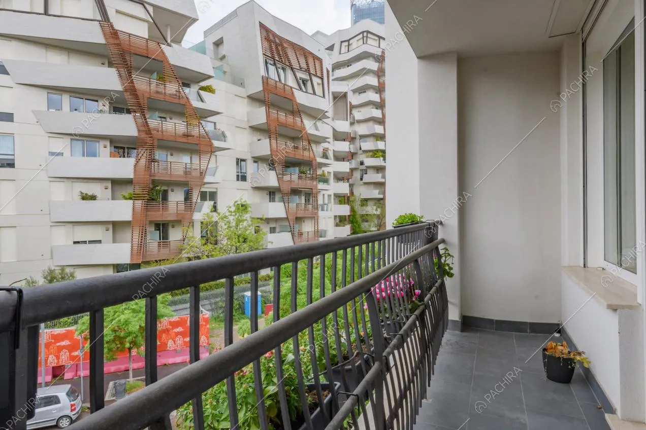 Balcone con parapetto in metallo nero e pavimento in piastrelle grigie