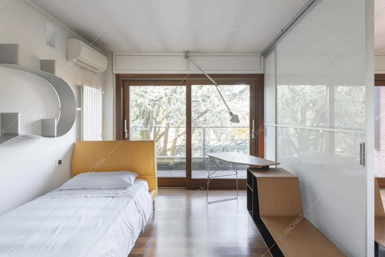 Camera con letto e libreria di design appesa alla parete
