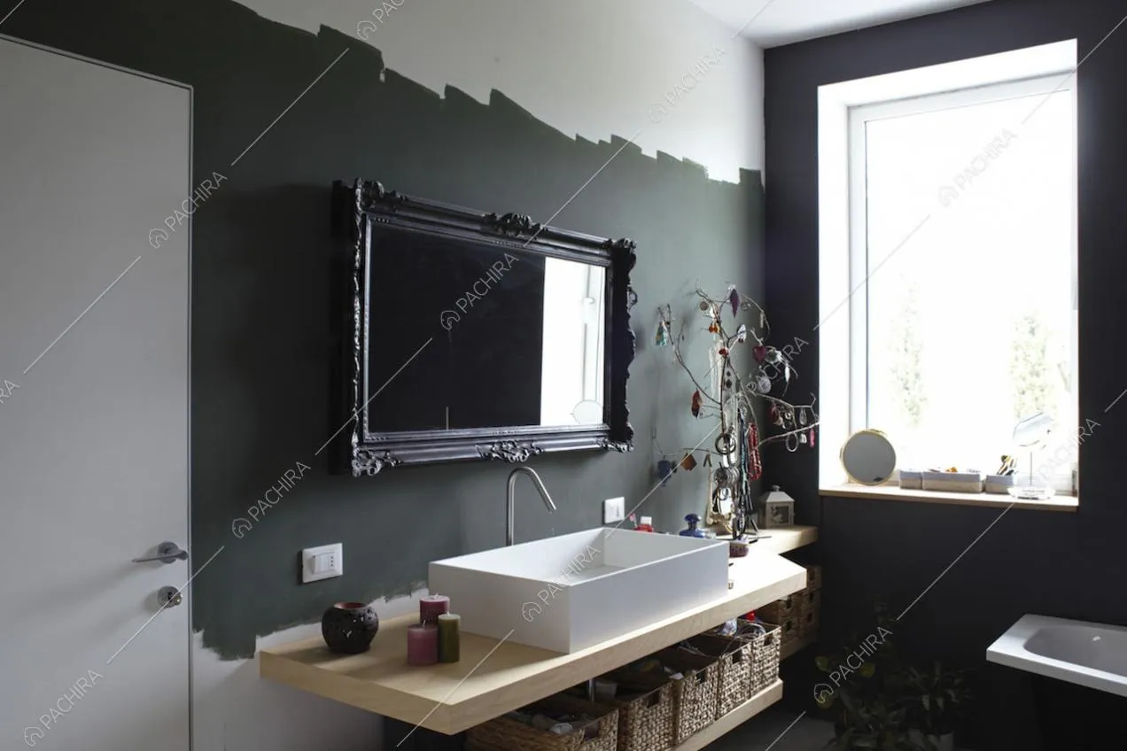Pareti nere e specchio con cornice decorata nel bagno