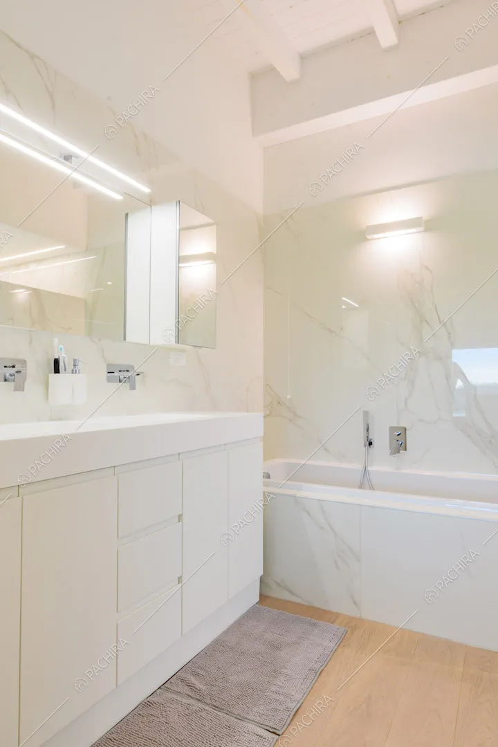 Pavimento in parquet nel bagno con vasca e pareti in marmo