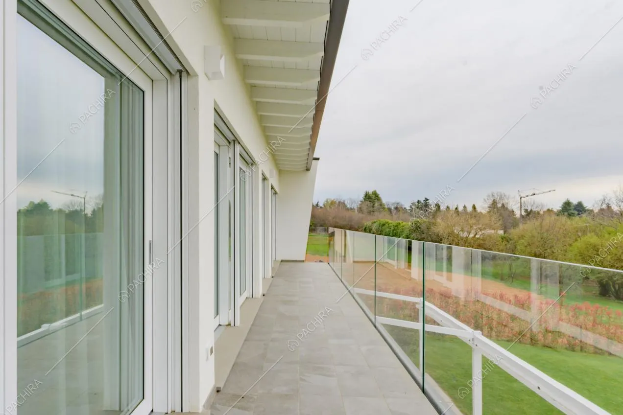 Ringhiera in vetro sulla terrazza con porte-finestre scorrevoli