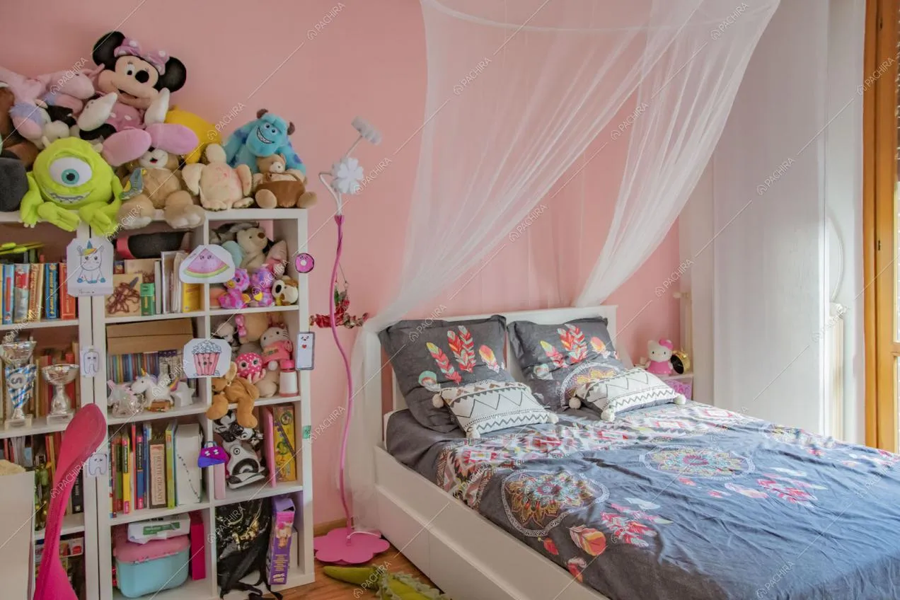 Camera da letto dei bambini con parete rosa e pavimento in parquet