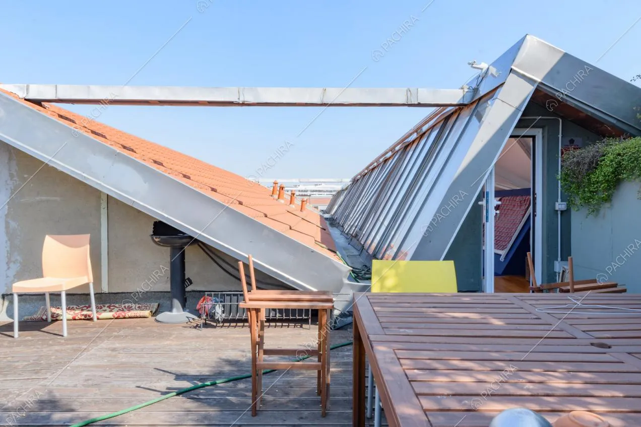 Grande terrazza con porta-finestra, pavimento in parquet da esterni e tavolo da pranzo