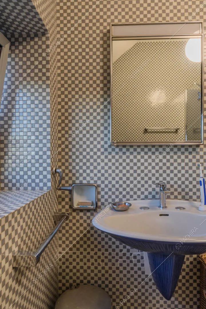 Bagno con piccole piastrelle bianche e grigie