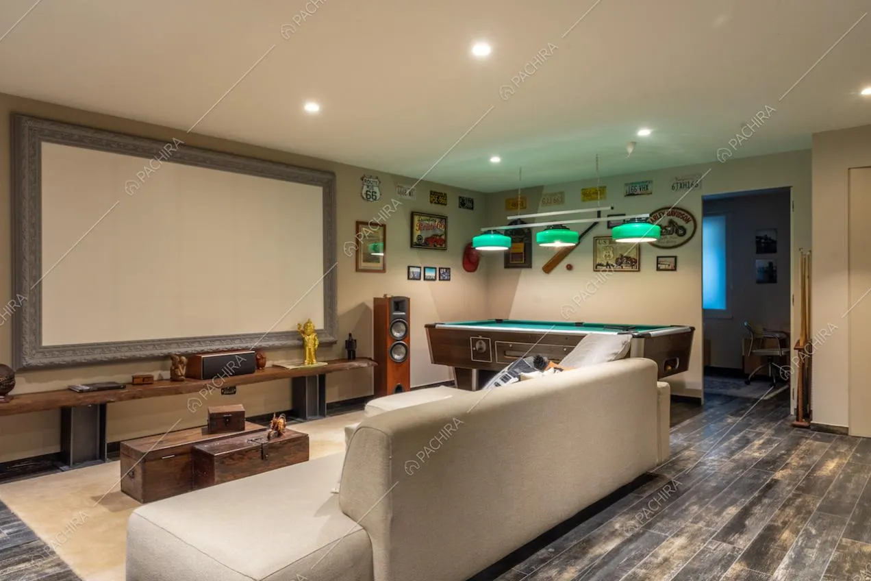 Sala cinema con biliardo, impianto stereo, divano bianco e pavimento in parquet
