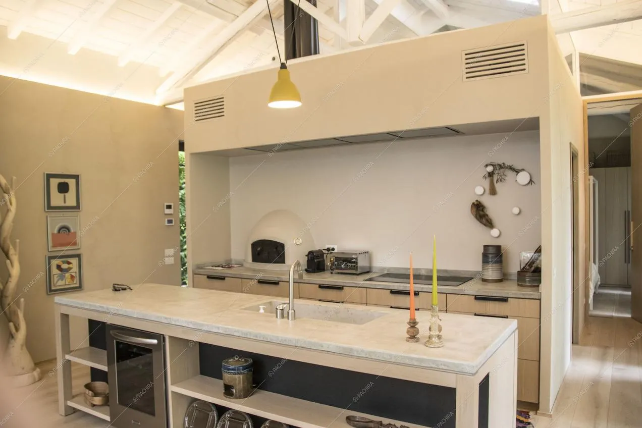 Cucina a isola beige con piano di lavoro in marmo chiaro