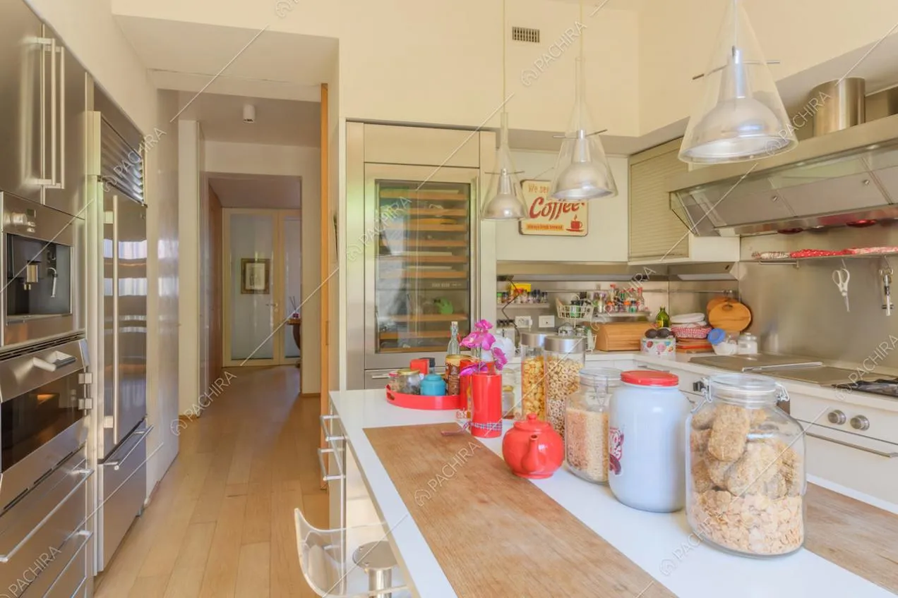 Cucina a isola con cantinetta, fornelli a gas e pavimento in parquet