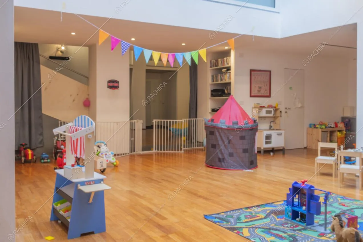 Giochi per bambini sul pavimento in parquet e faretti sul suffitto