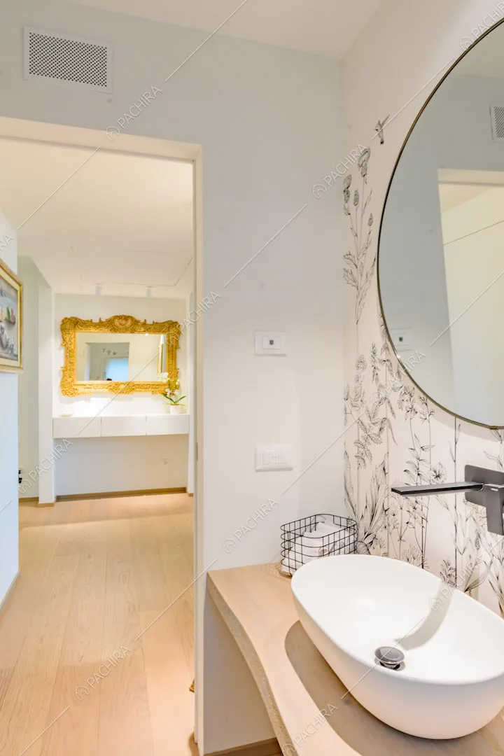 Bagno con carta da parati a tema floreale e pavimento in parquet