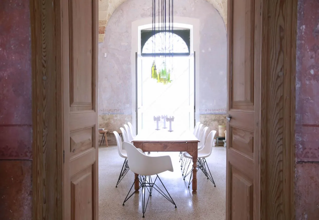 Tavolo da pranzo in legno con sedie bianche nella luminosa sala