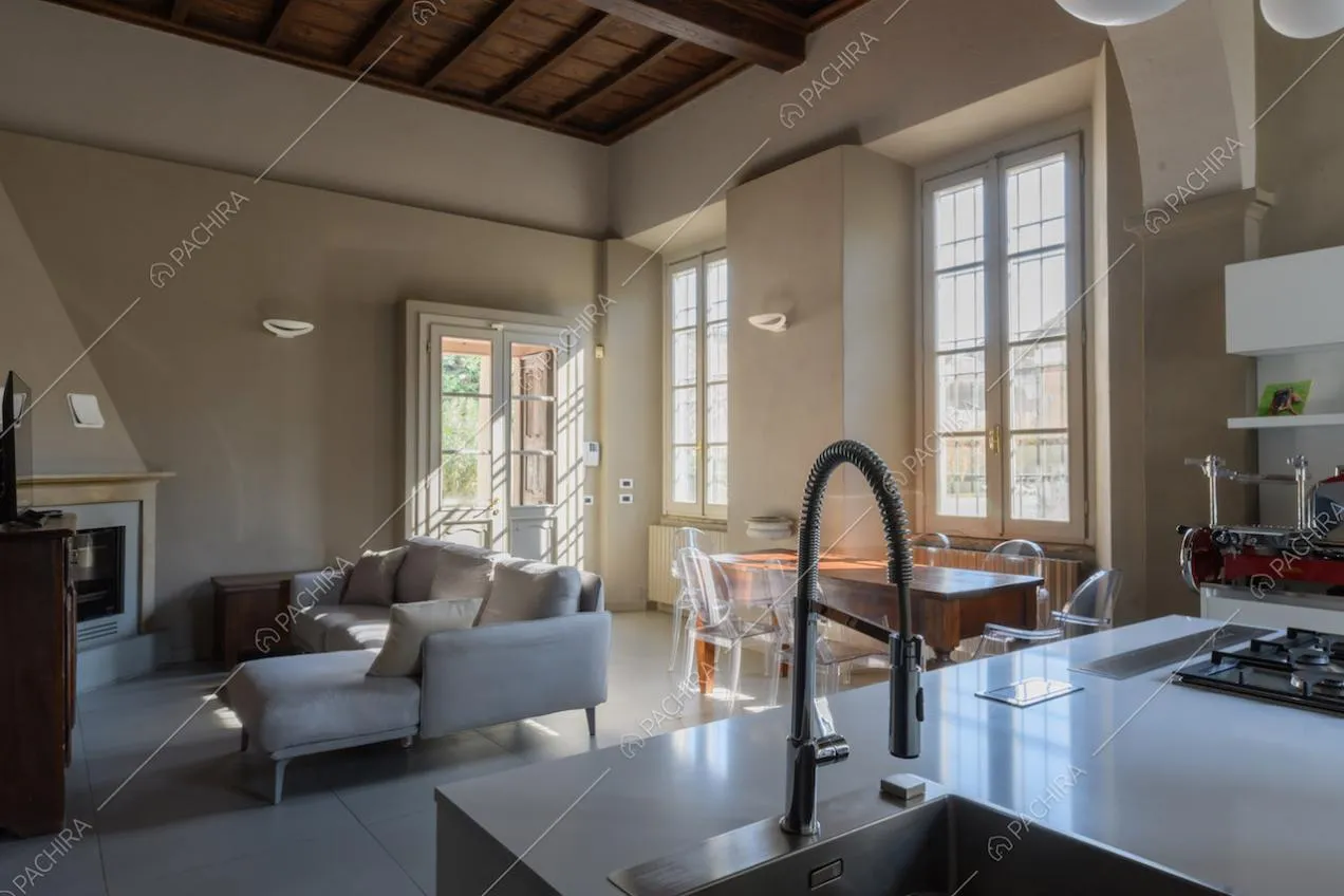 Isola con fornelli a gas nella cucina con soffitto a cassettoni e vista sul camino