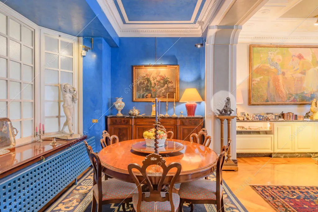 Tavolo da pranzo nella sala con pareti blu dell'appartamento Agazzino, location in stile classico a Milano