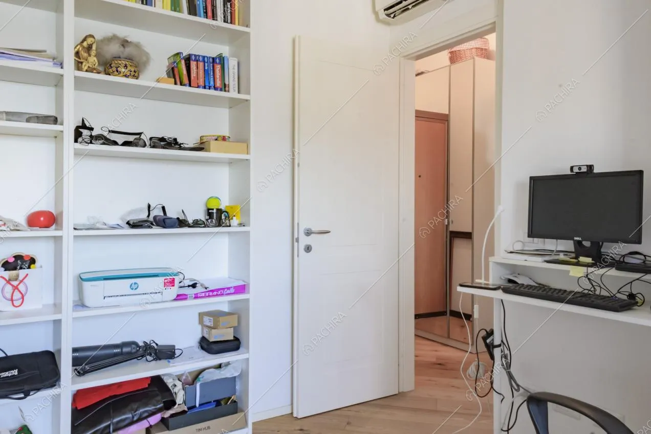 Computer su piccolo ripiano e scaffale bianco 
