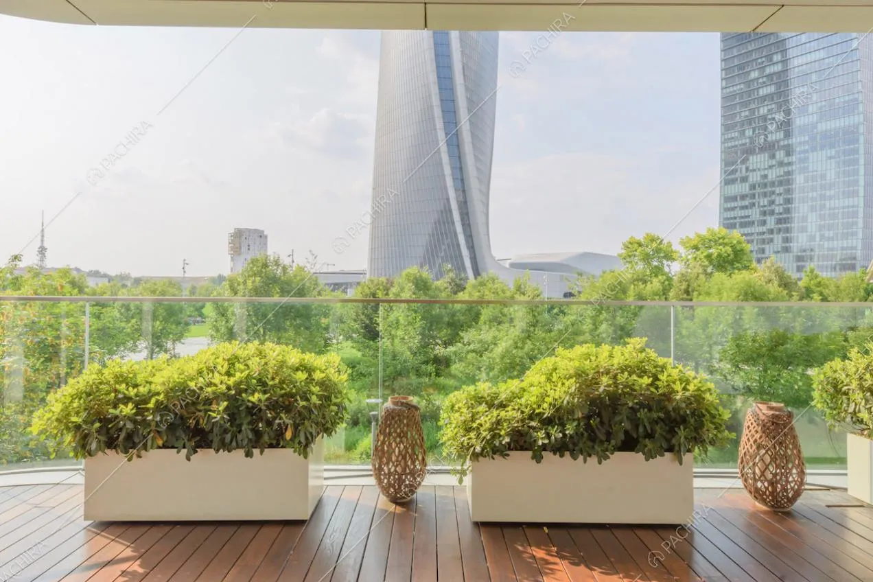 Vista sullo skyline dalla terrazza con parapetto in vetro e pavimentazione in parquet