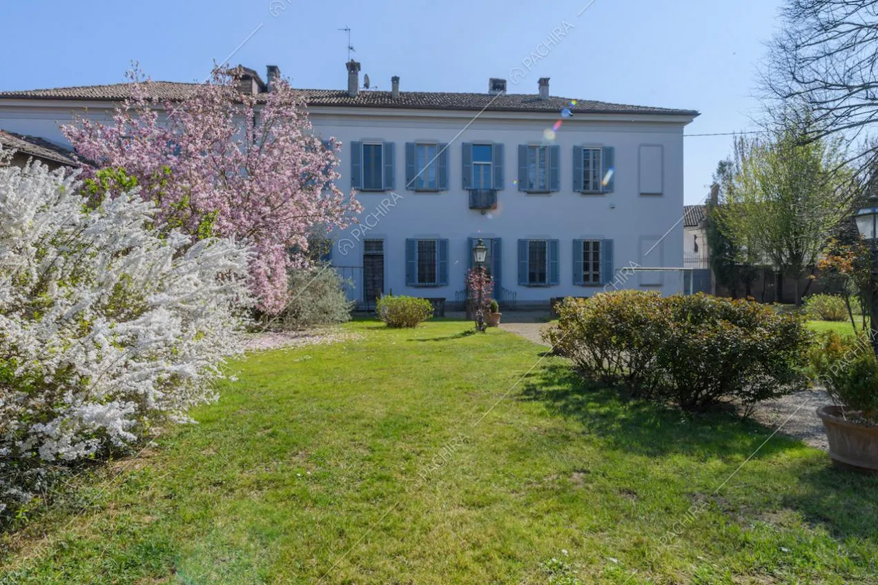 Grande giardino con piante, vialetto e vista sugli esterni bianchi della location