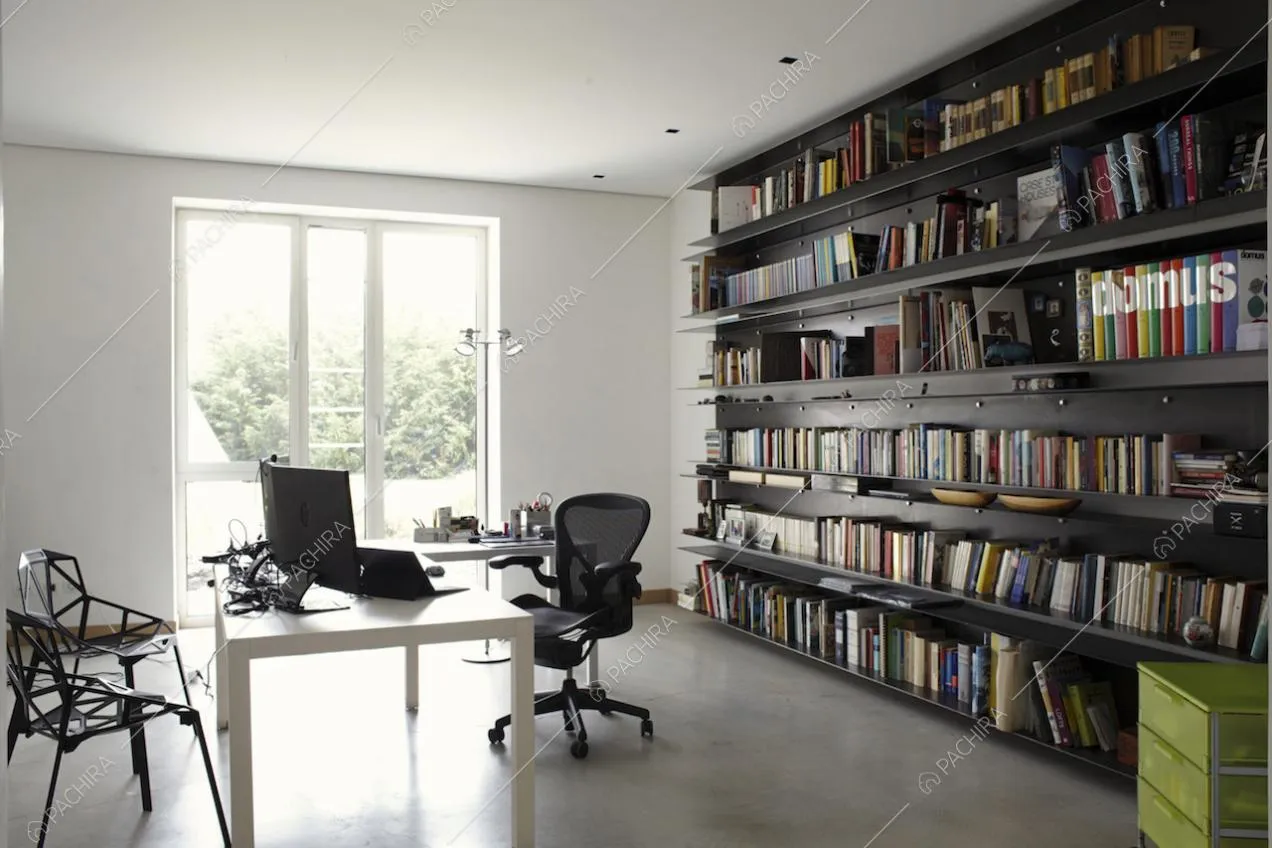 Studio con scrivania, sedie nere e grande libreria