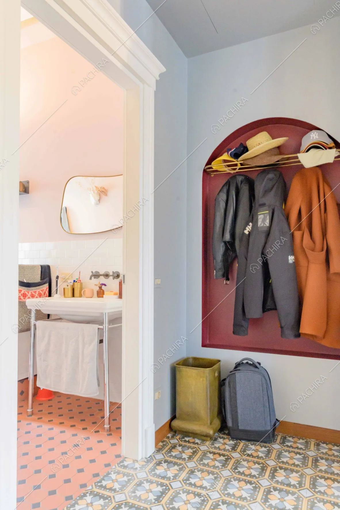 Atrio con pavimento in piastrelle con fantasia colorata, scorcio sul bagno e nicchia con appendiabiti