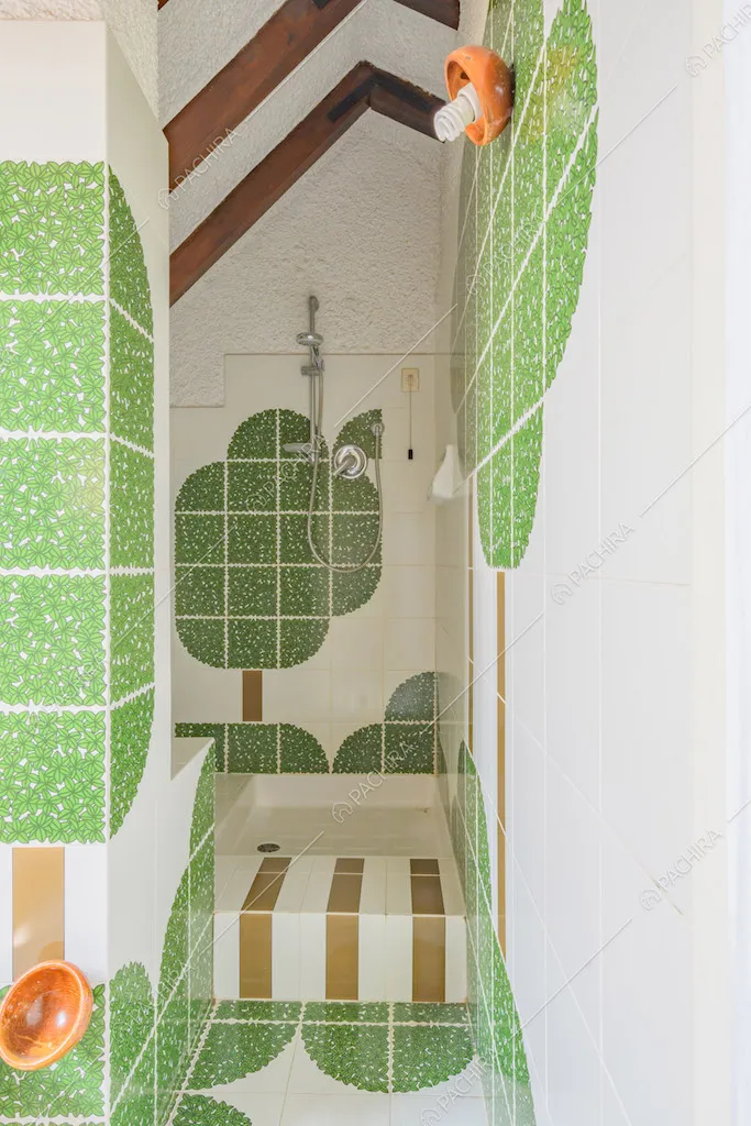 Bagno con box doccia e piastrelle bianche e verdi su pavimento e pareti