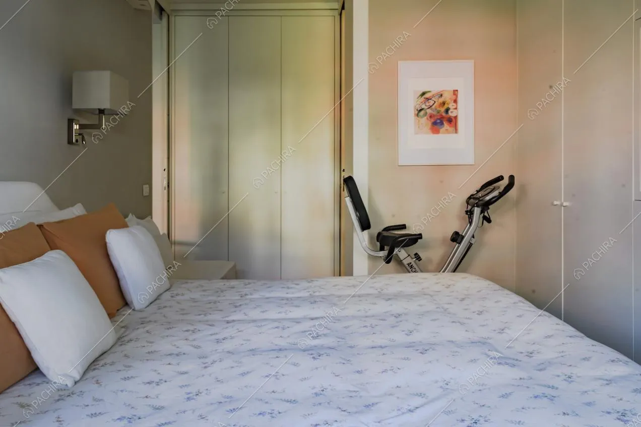 Letto matrimoniale con cuscini e applique da parete