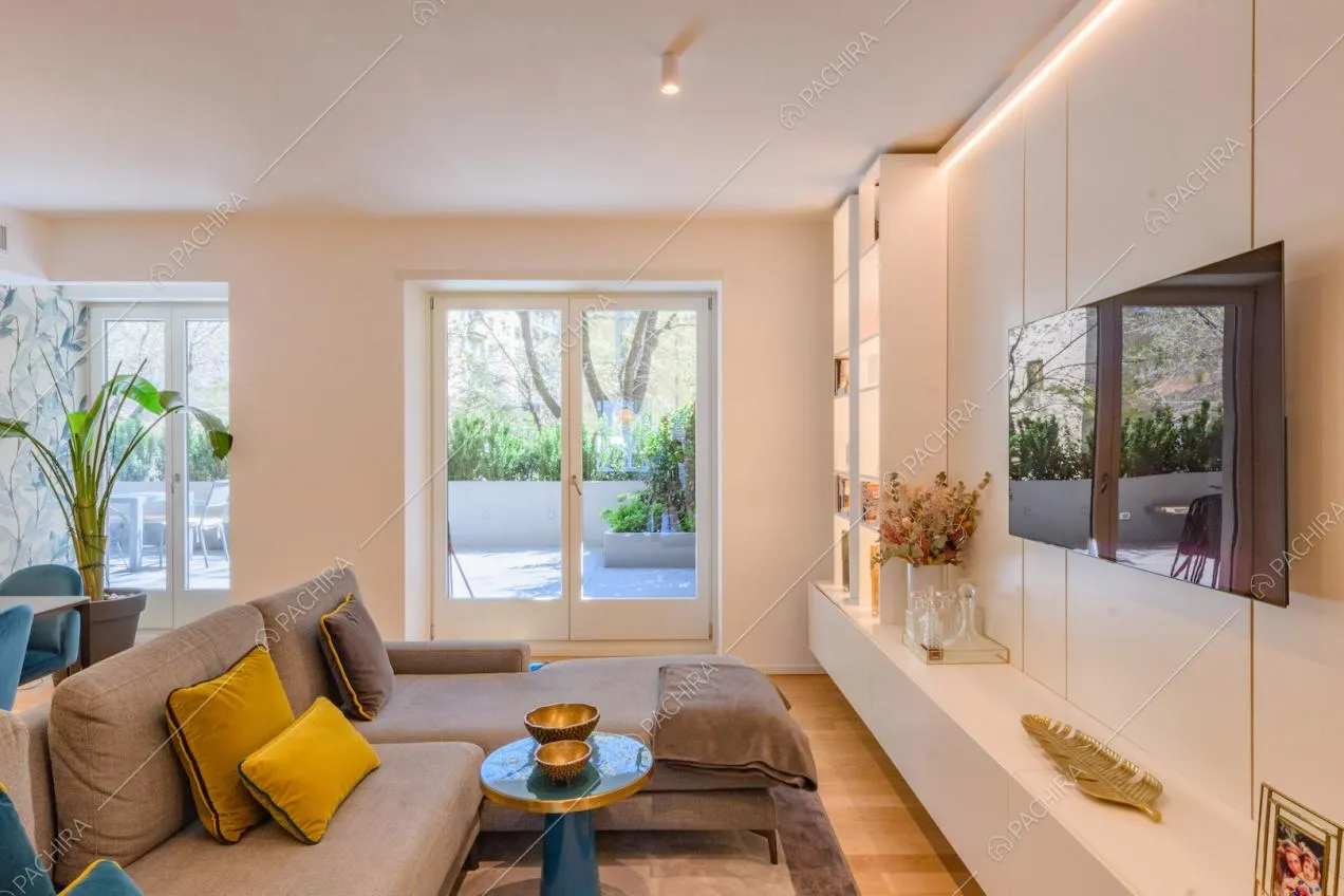 Divano grigio angolare nella zona living con porte-finestre per accedere alla terrazza